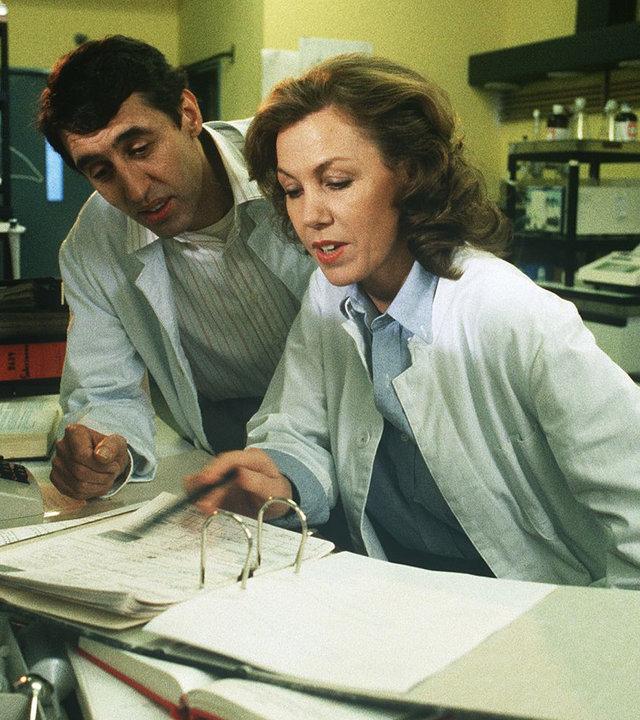"Die Schwarzwaldklinik - Nierenspende": Dr. Christa Brinkmann (Gaby Dohm) und ihr Kollege Dr. Heide (Jörg Pleva) schauen sich in einem Labor einen Aktenordner an.