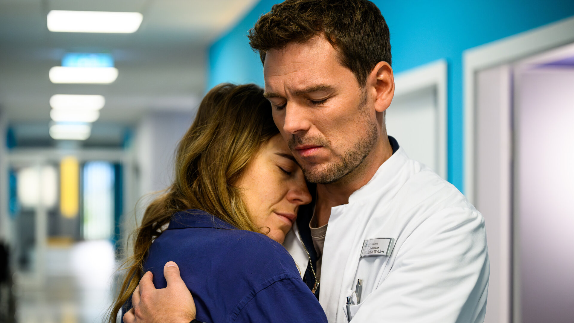 "Bettys Diagnose - Mamaleben": Im Krankenhausflur hält Dr. Julius Walden (Constantin Lücke) Betty (Henrike Hahn) fest im Arm. Beide haben dabei die Augen geschlossen.