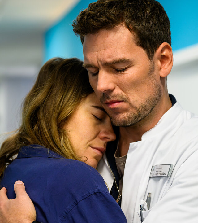 "Bettys Diagnose - Mamaleben": Im Krankenhausflur hält Dr. Julius Walden (Constantin Lücke) Betty (Henrike Hahn) fest im Arm. Beide haben dabei die Augen geschlossen.
