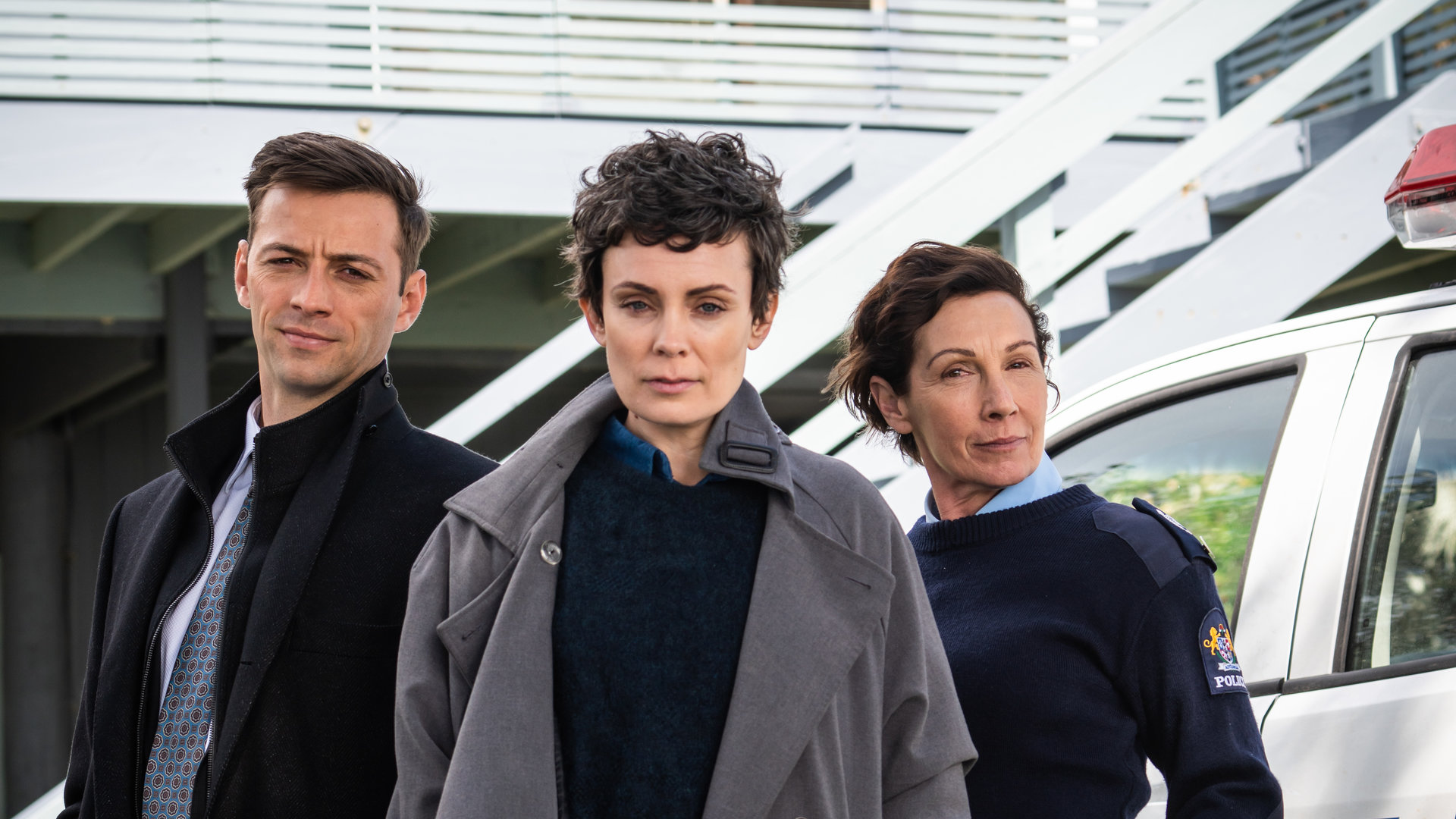 "Auckland Detectives - Tödliche Bucht: Neue Heimat": Detective Senior Sergeant Jessica Savage (Kate Elliott), ihr Kollege Detective Sergeant Justin Harding (Ido Drent) und Senior Sergeant Denise Abernethy (Alison Bruce) stehen in Nahaufnahme vor der Polizeistation in Waiheke.