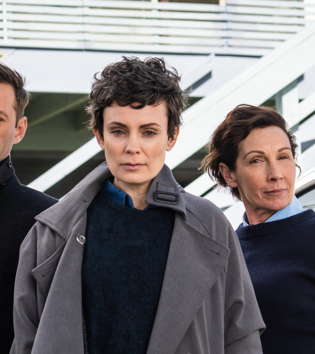 "Auckland Detectives - Tödliche Bucht: Neue Heimat": Detective Senior Sergeant Jessica Savage (Kate Elliott), ihr Kollege Detective Sergeant Justin Harding (Ido Drent) und Senior Sergeant Denise Abernethy (Alison Bruce) stehen in Nahaufnahme vor der Polizeistation in Waiheke.
