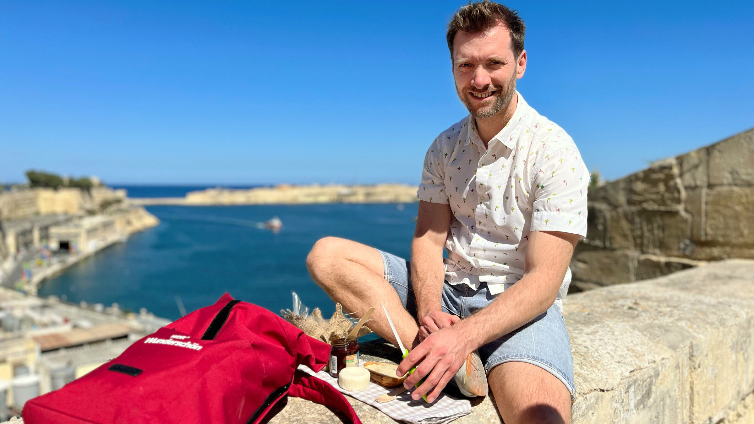 "Malta": Moderator Daniel Aßmann bei einem kleinen Picknick mit maltesischen Spezialitäten und Blick auf den Hafen von Valletta.