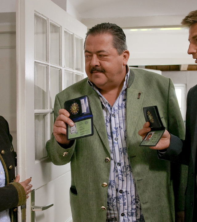 "Die Rosenheim-Cops - Ein mörderischer Verdacht": Kommissar Hofer (Joseph Hannesschläger) und Kommissar Hansen (Igor Jeftic) stehen Lene Eberl (Isabel Mergl) in der Tür gegenüber und zeigen ihr ihre Polizeimarke.