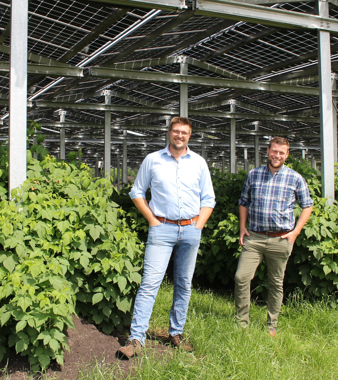 "Terra Xpress: Clever - Umdenken fürs Klima": Die Landwirte Fabian Karthaus und Josef Kneer stehen vor einem großen, überdachten Gewächshaus und lächeln in die Kamera.
