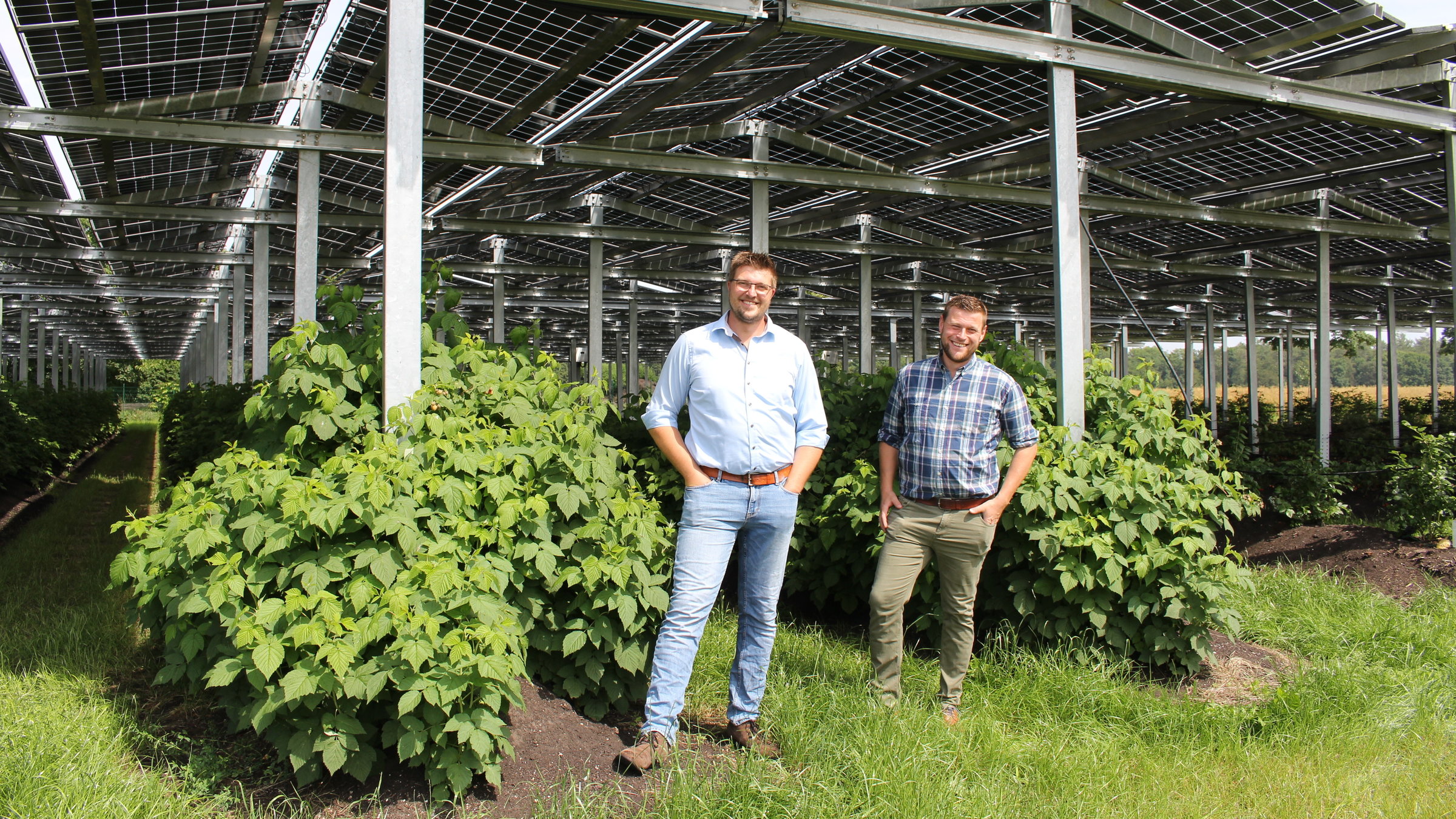"Terra Xpress: Clever - Umdenken fürs Klima": Die Landwirte Fabian Karthaus und Josef Kneer stehen vor einem großen, überdachten Gewächshaus und lächeln in die Kamera.