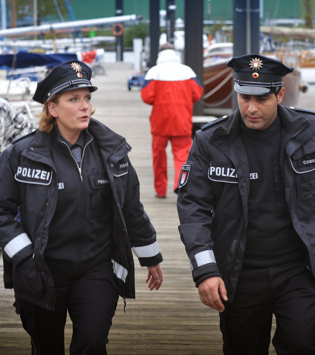 "Notruf Hafenkante - Eltern - nein, danke!": Claudia (Janette Rauch) und Tarik (Serhat Cokgezen) laufen am Yachthafen entlang und sehen sich um.