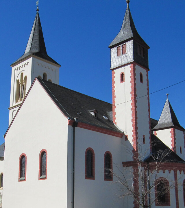 "Evangelischer Gottesdienst – Kopf hoch": Vor strahlend blauem Himmel hebt sich das Weiß der Ingelheimer Saalkirche mit ihren drei filigranen Türmen ab.