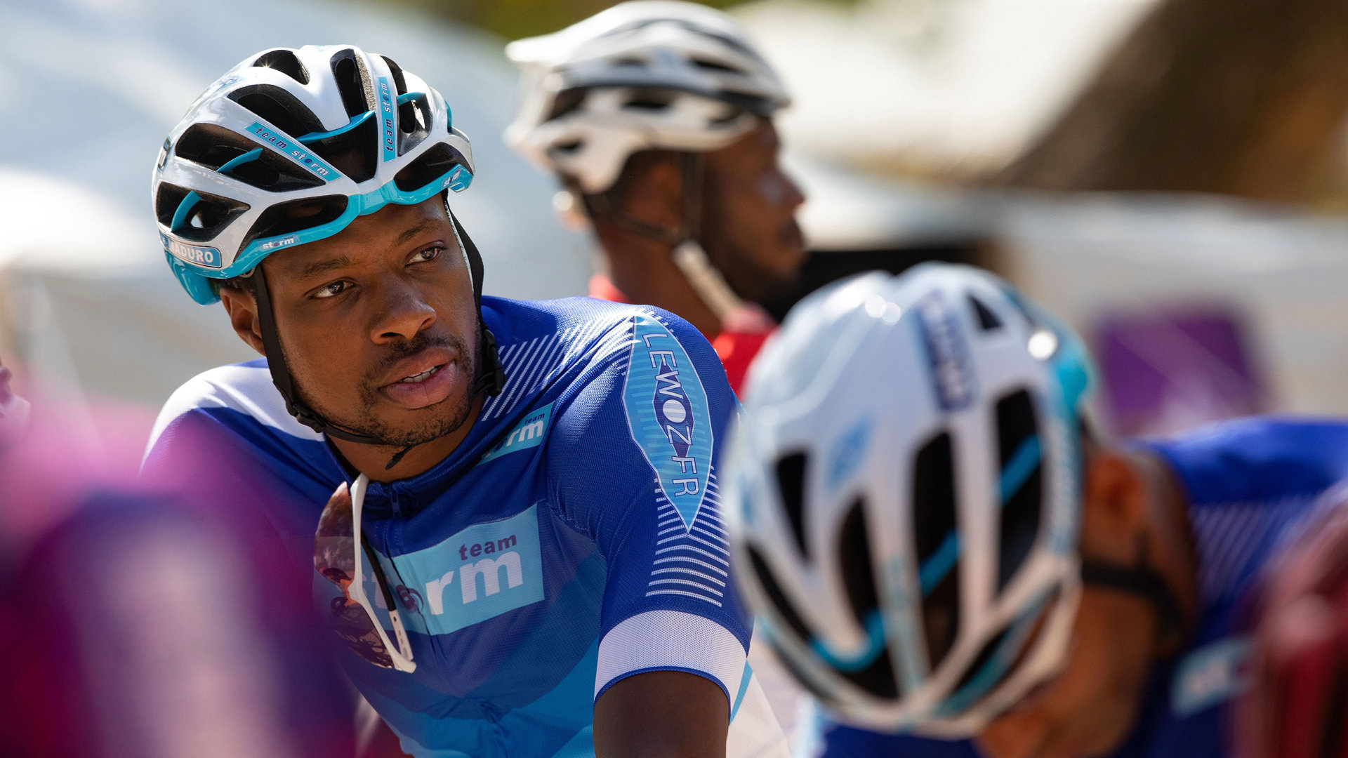 "Death in Paradise - Gegen die Uhr": Anton Maduro (Osi Okereafor) sitzt mit Fahrradmontur auf seinem Rennrad.