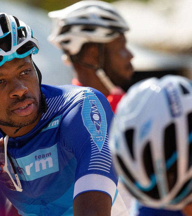 "Death in Paradise - Gegen die Uhr": Anton Maduro (Osi Okereafor) sitzt mit Fahrradmontur auf seinem Rennrad.