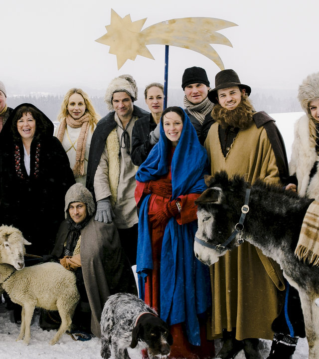 "Beste Bescherung": Malia (Cynthia Micas), Aimer (Jan Messutat), Karl (Friedrich von Thun), Rosalie (Gundi Ellert), Susan (Petra Schmidt-Schaller), Ben (Misel Maticevic), Anna (Sophie von Kessel), Miriam (Anneke Schwabe), Tom (Fabian Hinrichs), Stefan (Frederic Linkemann), Dina (Franziska Schlattner), Sharif (Arian Montgomery) und stehen in einer Gruppe zusammen, davor sitzt Vince (Marc Hosemann) in einer verschneiten Landschaft. Vor der Gruppe stehen Schafe, ein Hund und ein Esel, auf dem Sharif (Arian Montgomery) sitzt. In der Mitte hält jemand einen großen Stern an einem Stab hoch.