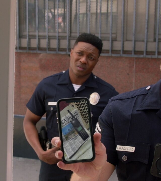"The Rookie - Alte Wunden": Officer Tim Bradford (Eric Winter) zeigt seinem Gegenüber ein Foto des Polizeifunkgeräts auf seinem Smartphone, während Aaron Thorsen (Tru Valentino) skeptisch zuschaut.