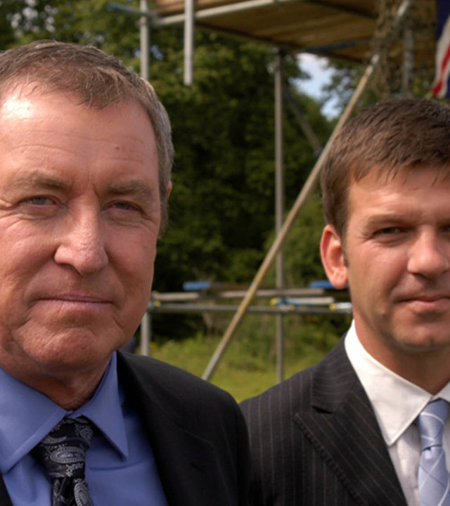 "Inspector Barnaby - Wenn der Morgen graut": DCI Tom Barnaby (John Nettles) und DS Ben Jones (Jason Hughes) stehen nebeneinander und lächeln in die Kamera.