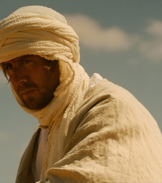 "Exit - William von Arabien": William (Pål Sverre Hagen) steht nachdenklich in der Sonne, gekleidet in ein Leinengewand und einen Turban.