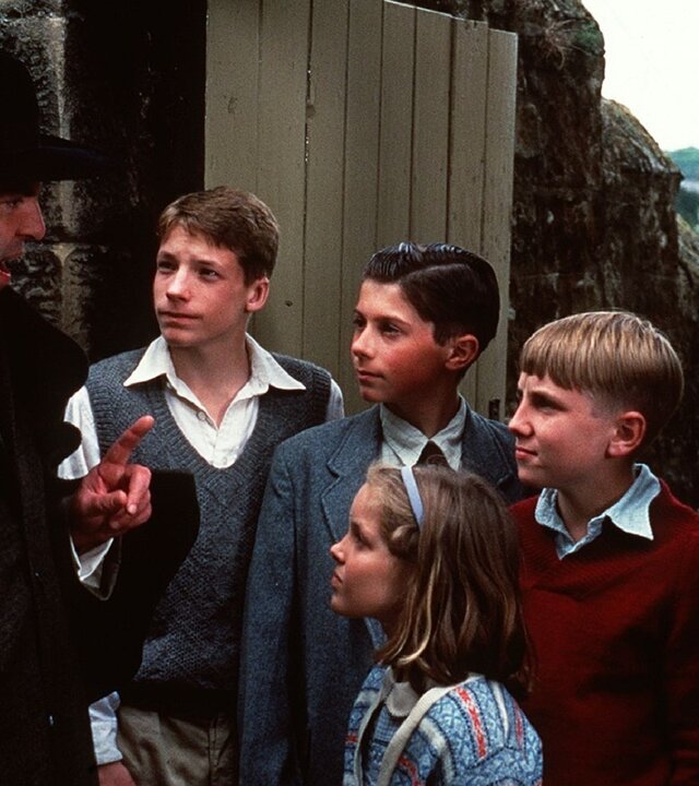 "Fünf Freunde auf Schmugglerjagd (1)": Die Kinder Julian (Marco Williamson), Pete (Ian Aherne), Dick (Paul Child), George (Jemima Rooper) und Anne (Laura Petela) blicken aufmerksam zu Barling (Jeremy Sinden), der vor ihnen steht und mit erhobenem Zeigefinger etwas erklärt.