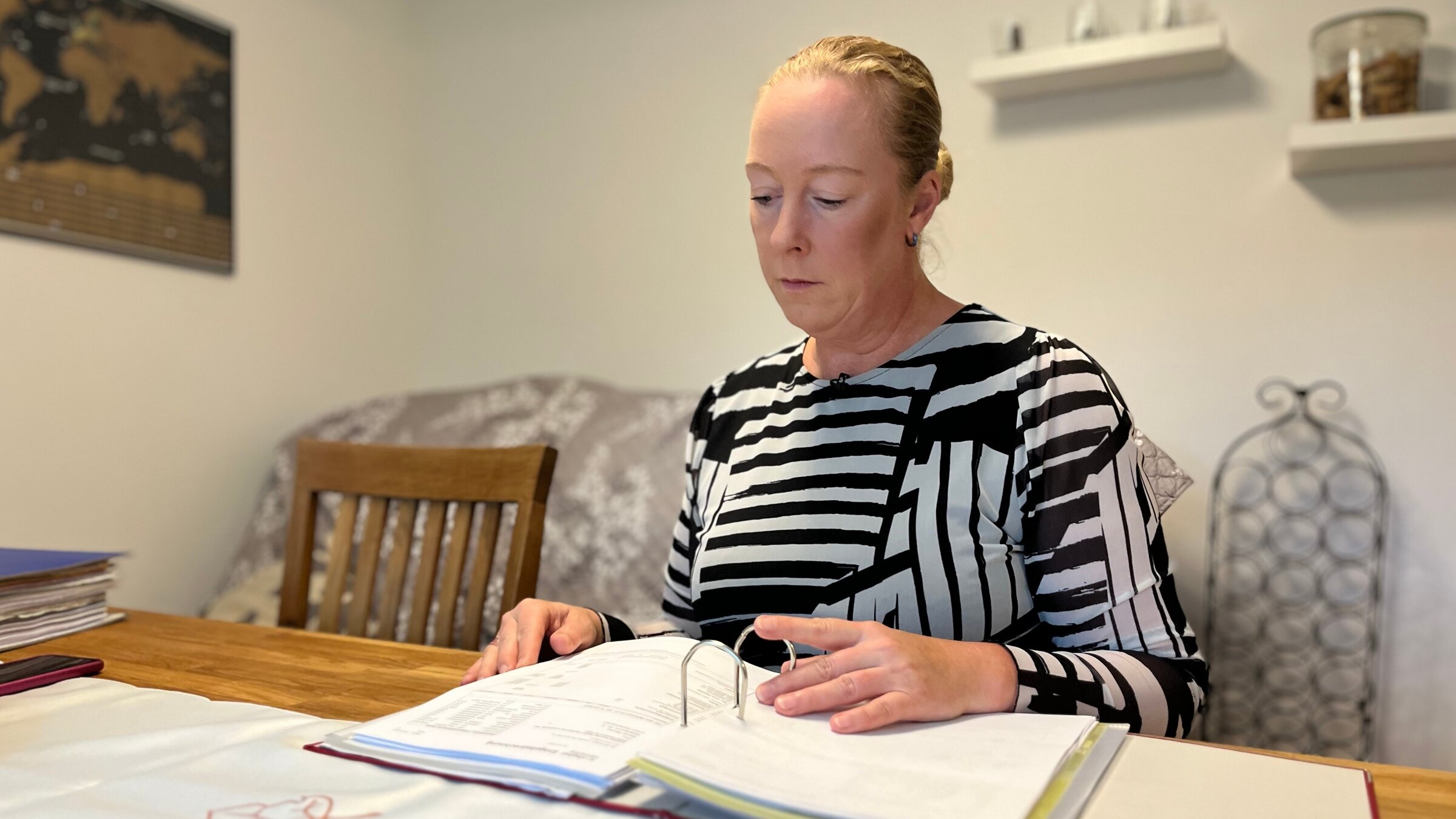 "ZDF.reportage: Frauen in der Armutsfalle - Viel Arbeit, wenig Lohn": Mandy Mewes sitzt am Tisch, vor ihr liegt ein Ordner mit Rechnungen.