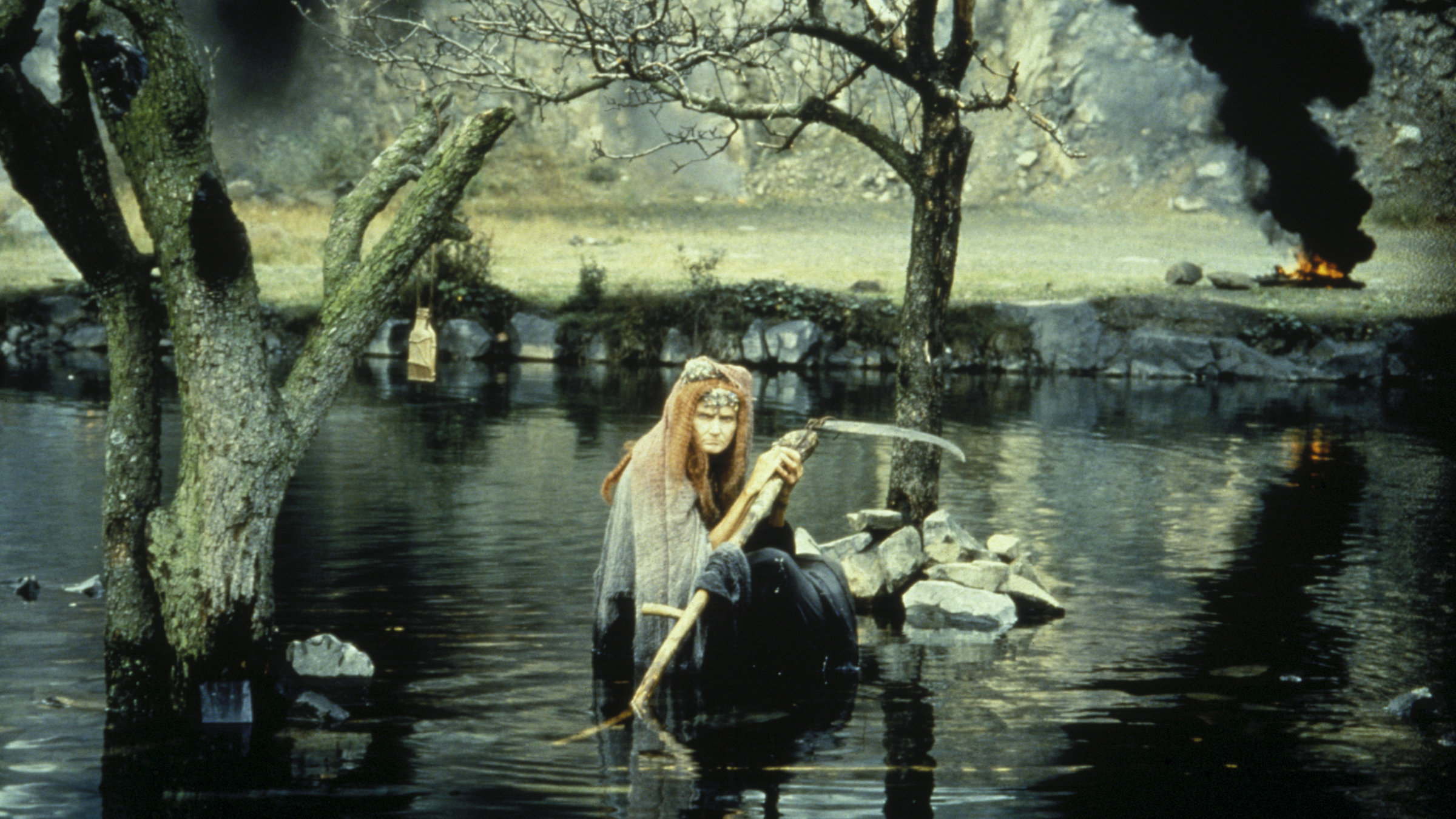 "Frau Holle": Frau Hippe (Valerie Kaplanová) steht im Wasser und hält die Sense in der Hand.