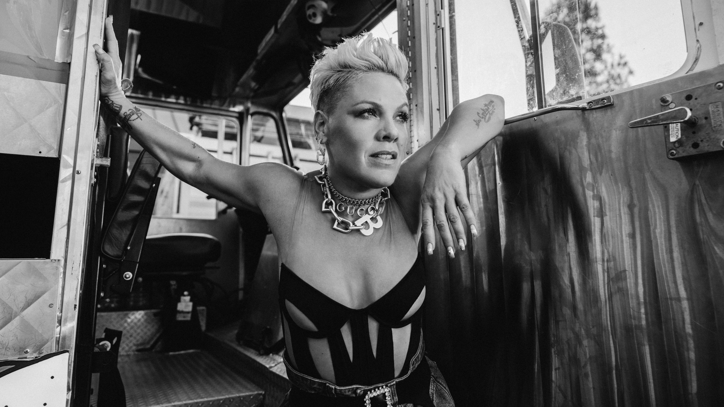 "P!NK: Funhouse": Die Sängerin P!NK steht mit ausgebreiteten Armen vor der geöffneten Tür eines Lastwagens und blickt in die Ferne (s/w).
