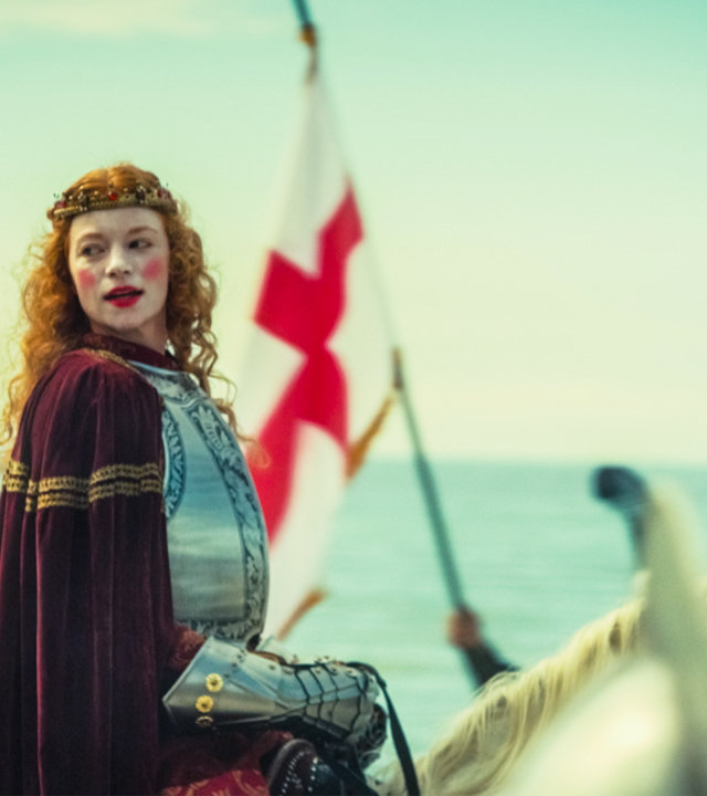 "Die glorreichen 10 - Die größten Verwandlungen der Geschichte": Königin Elisabeth I. von England reitet in einer Rüstung am Strand entlang. Hinter weht die englische St. George-Flagge.