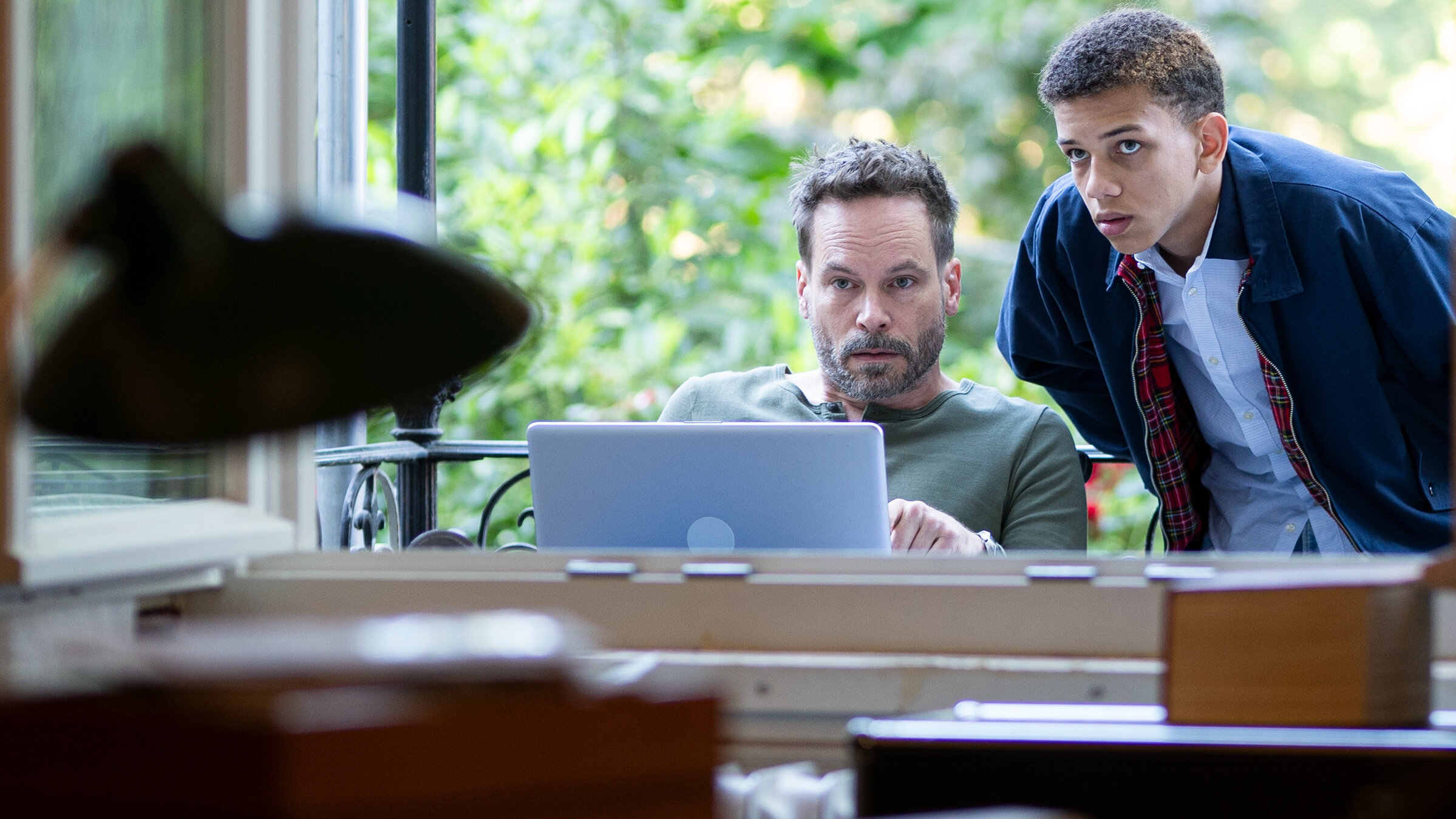 "Ein Fall für zwei - Spurlos verschwunden": Leo Oswald (Wanja Mues) sitzt am Schreibtisch, hinter ihm steht Praktikant Farrokh (Salimou Thiam). Sie schauen beide erwartungsvoll in den Raum. Vor ihnen steht ein aufgeklappter Laptop.