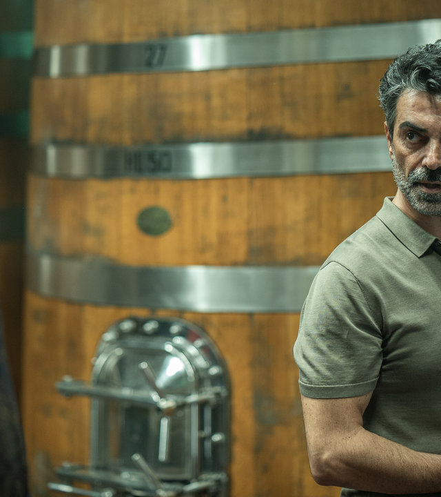 "Im Netz der Camorra":  Nino Sorrentino (Fabrizio Romagnoli) steht vor einem riesigen Weinfass und schaut zu Leo Calavachi (Luca Filippi), der im Anschnitt zu sehen ist.
