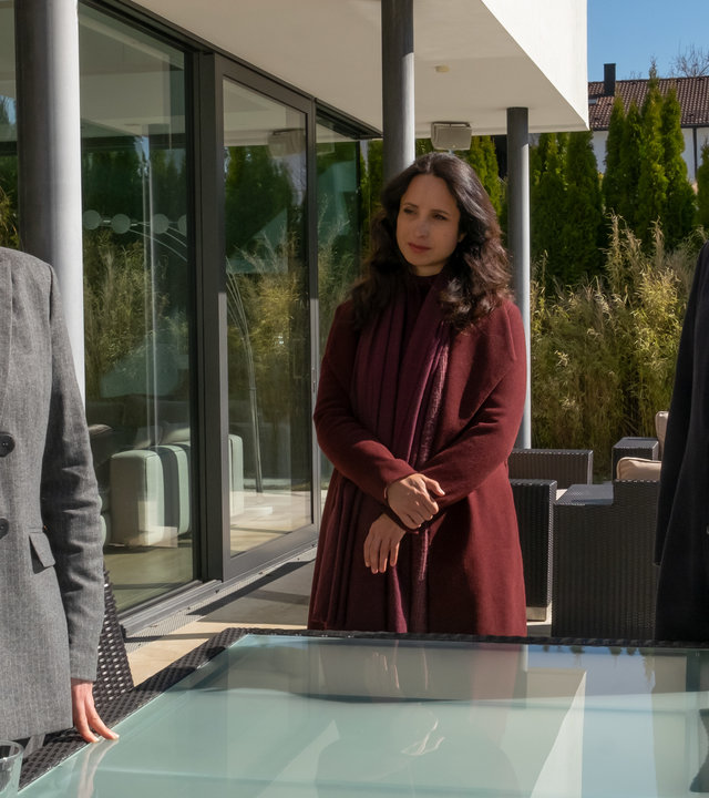 "Der Alte - Helden von nebenan": Marlies Benrath (Valerie Koch) steht an ihrem Verandatisch und telefoniert. Annabell Lorenz (Stephanie Stumph) und Richard Voss (Jan Gregor Kremp) stehen daneben und schauen sie fragend an.