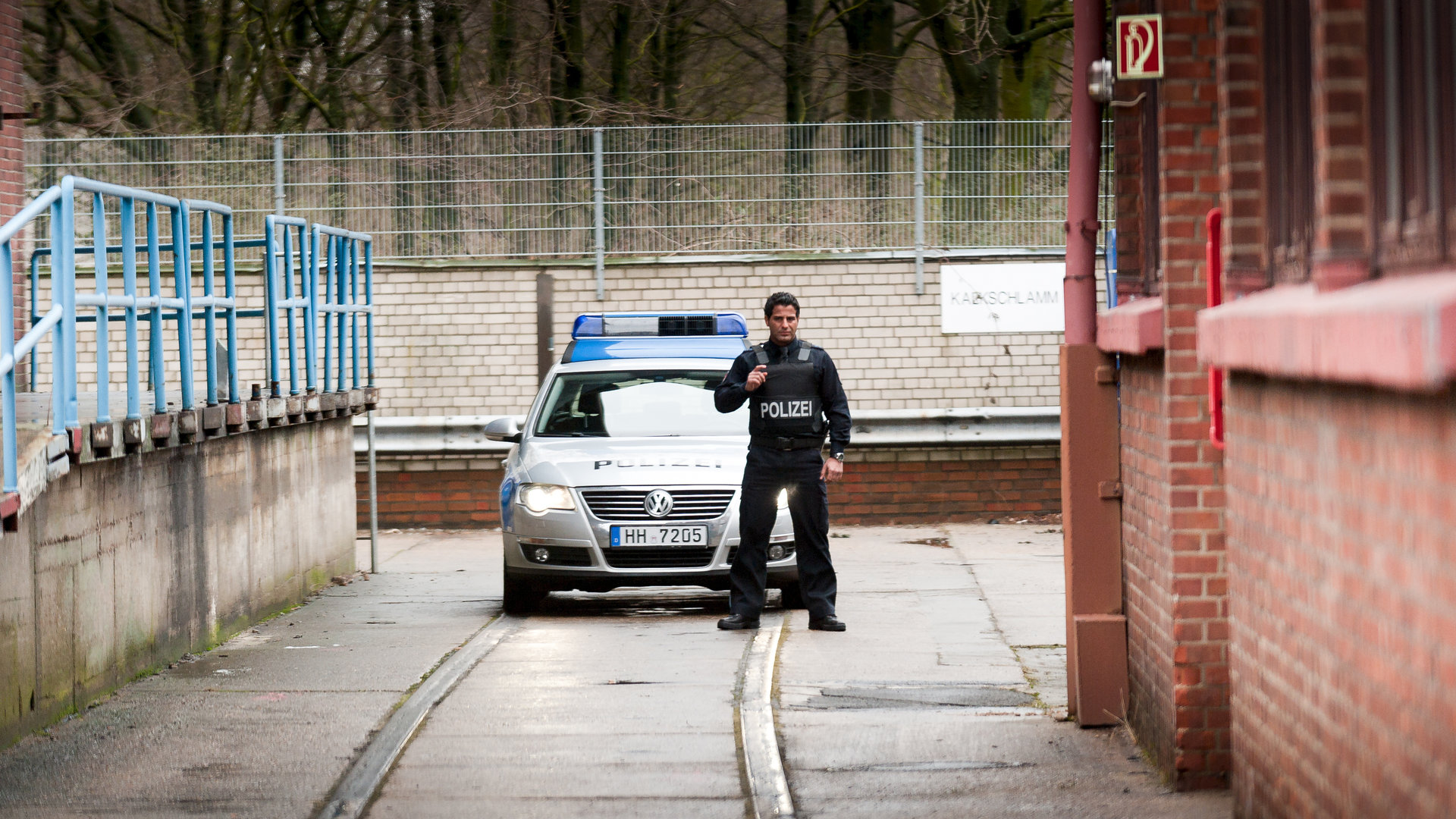 "Notruf Hafenkante - Recht und Gerechtigkeit": Tarik (Serhat Cokgezen) steht mit vorgehaltener Waffe, einsatzbereit vor dem Polizeiwagen.