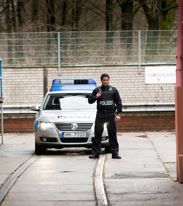 "Notruf Hafenkante - Recht und Gerechtigkeit": Tarik (Serhat Cokgezen) steht mit vorgehaltener Waffe, einsatzbereit vor dem Polizeiwagen.