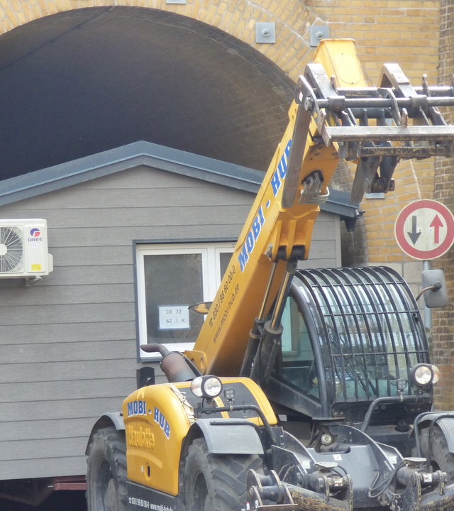 "Terra Xpress - Zu wenig, zu teuer - wird Wohnen zum Luxus?": Ein Bagger zieht ein Containerhaus durch einen Tunnel. Der Bagger ist bereits durch, das Haus noch nicht.