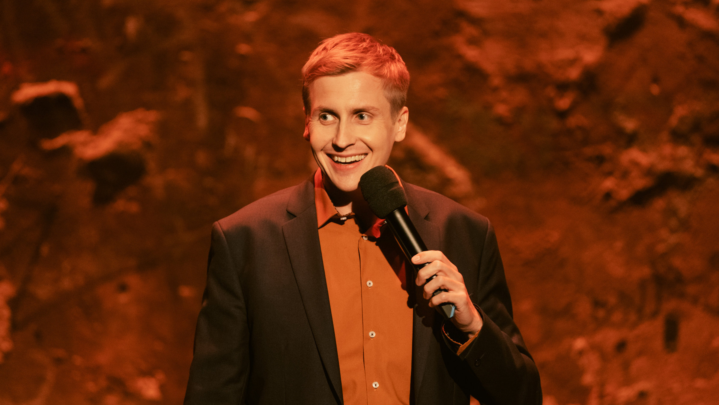 "Till Reiners` Happy Hour": Till Reiners steht auf der Bühne mit einem Mikrofon in der Hand.