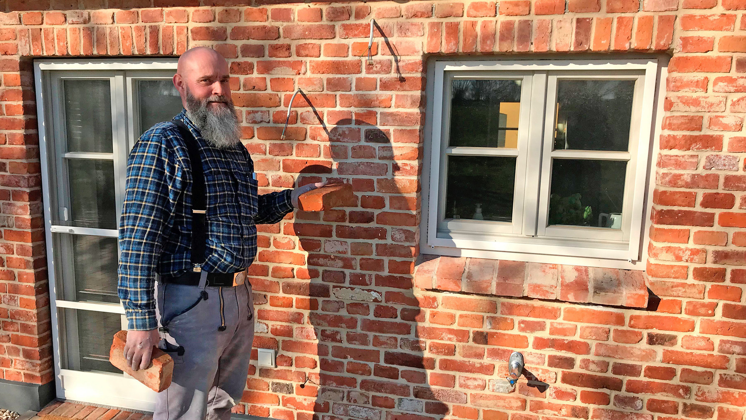 "Die Nordreportage: Von wegen steinalt": Maurer Bernd Thomsen vor einer alten Kate an der Flensburger Förde, die er mit historischen Ziegelsteinen restauriert hat.