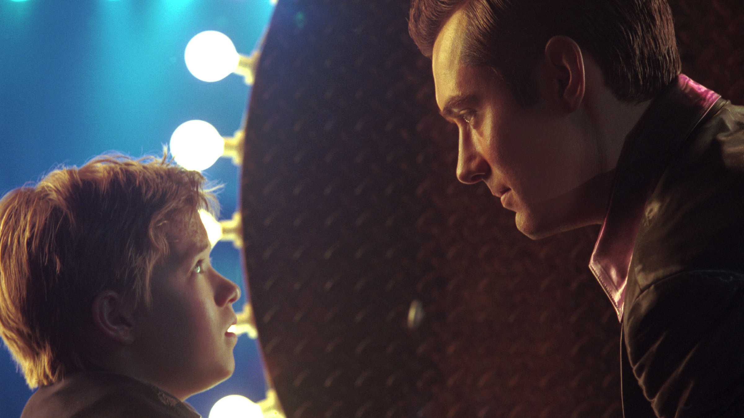 "A.I. - Künstliche Intelligenz": David (Haley Joel Osment) sitzt Joe (Jude Law) gegenüber. Die Beiden schauen sich dabei tief in die Augen.