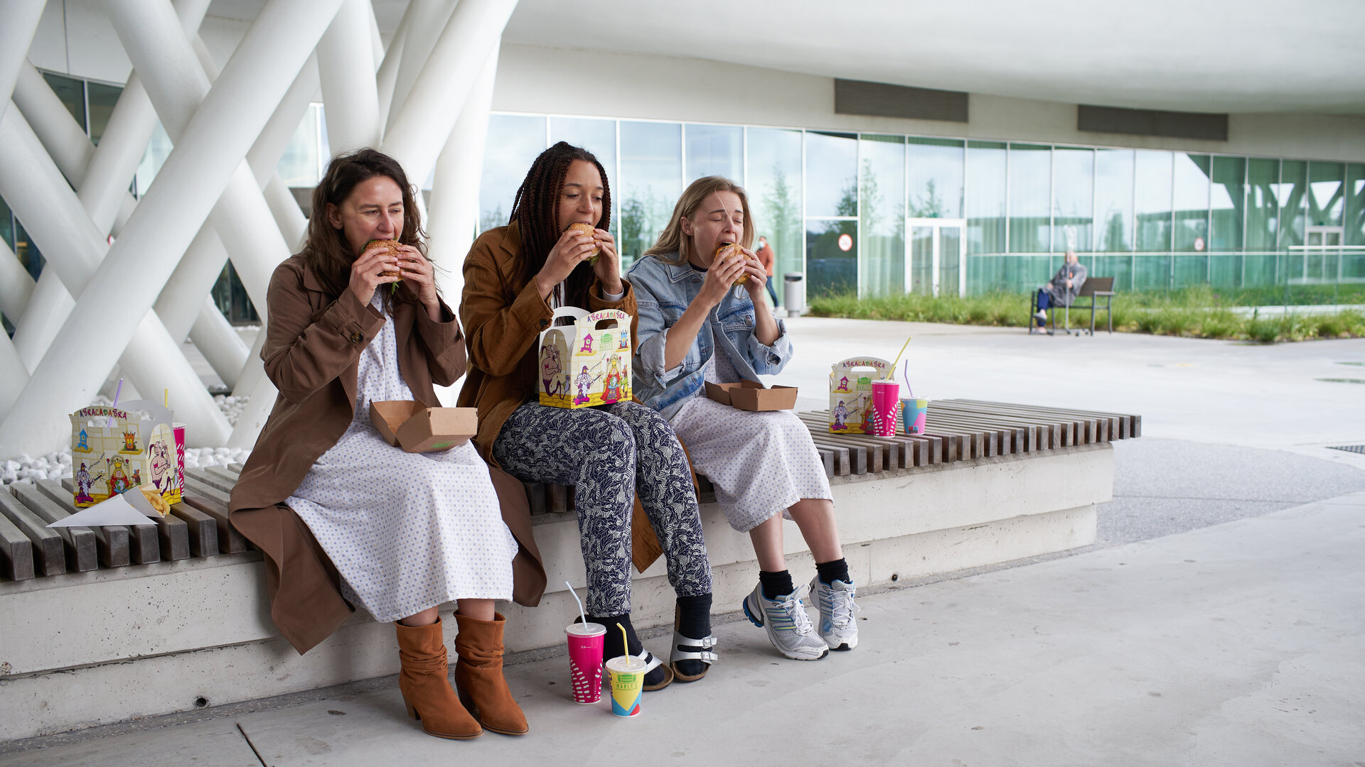 "The Club - Der Geburtstagskarten-Club": Kirstie (Janne Desmet), Ellen (Jade Olieberg) und Charlie (Roos Dickmann) essen genüsslich Burger vor der Klinik.