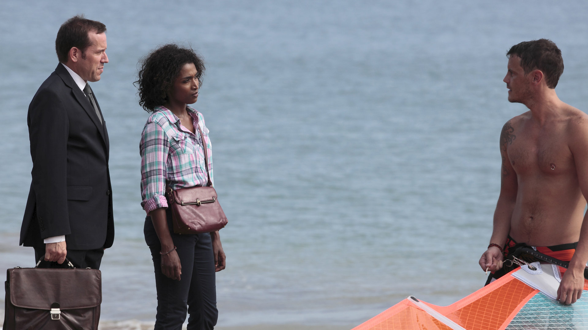 "Death in Paradise - Nur die Sonne war Zeuge": DI Richard Poole (Ben Miller) und Camille (Sara Martins) stehen mit Tauchlehrer Stefan (Daniel O''Connor) am Strand.