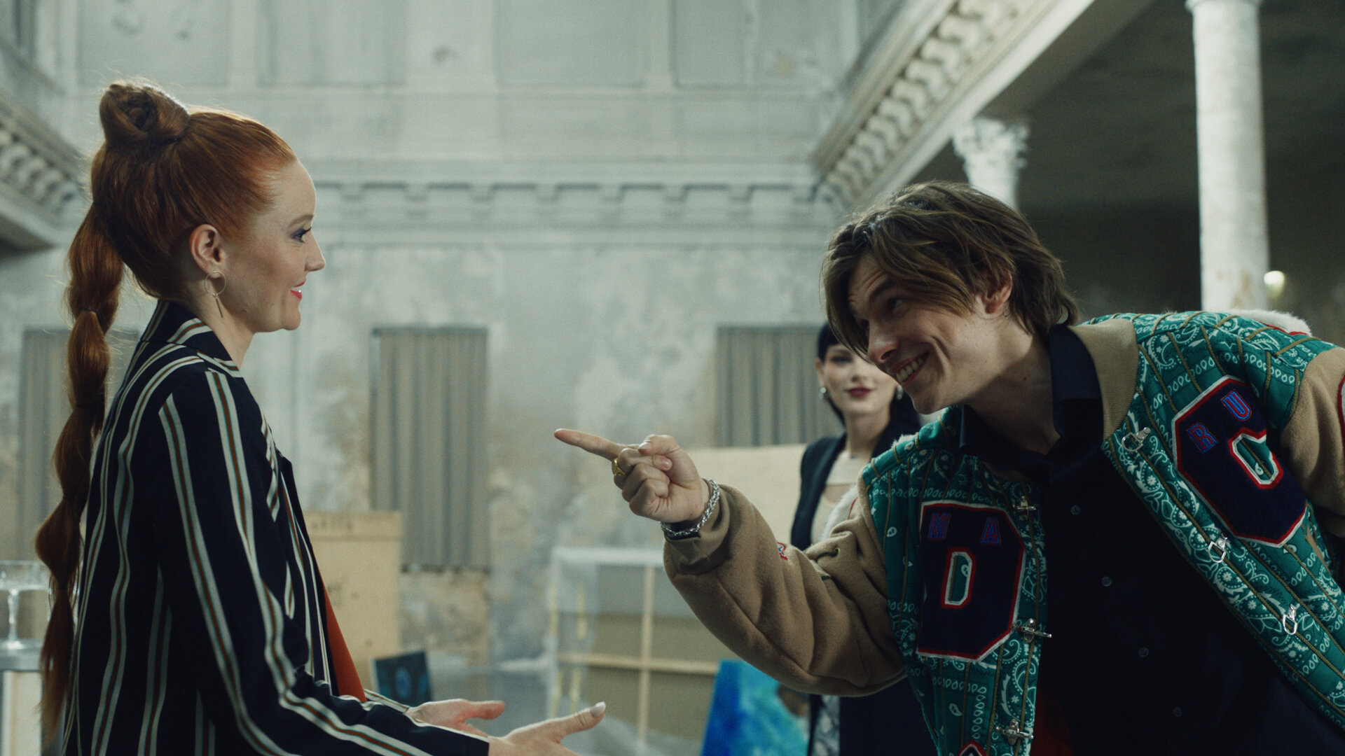 "Crystal Wall - Väter": Valerie (Barbara Meier) und Magdalena (Phenix Kühnert) stehen mit Nicolas Dardenne (Gustav Schmidt), der mit dem Finger in Valeries Richtung deutet, in einer großen Halle.