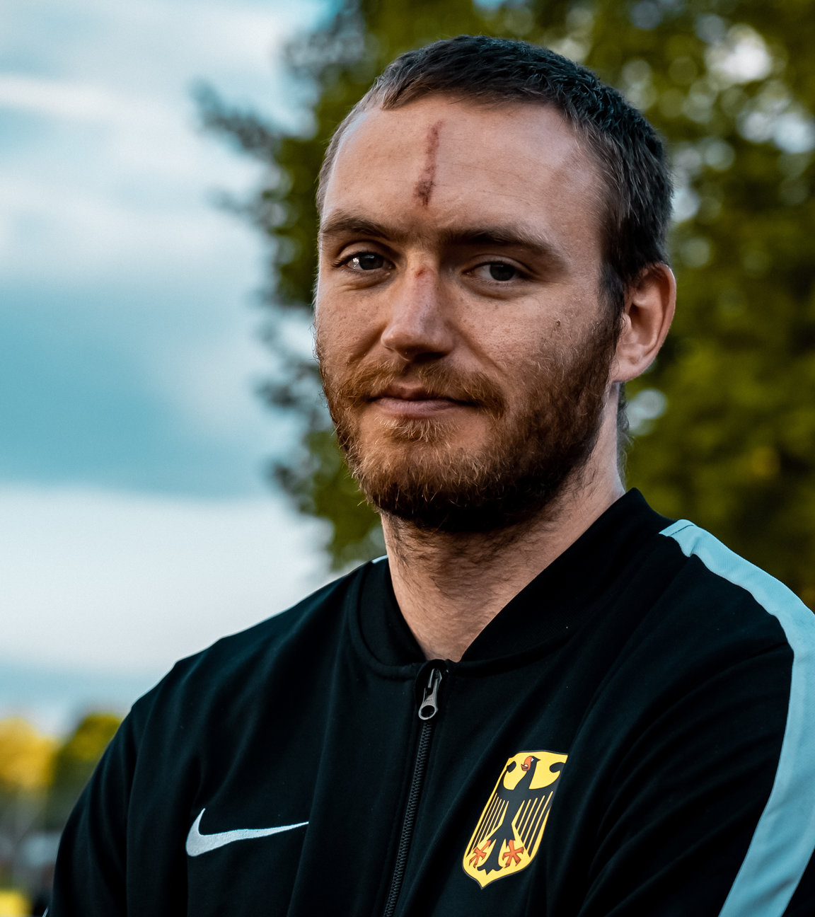 "einfach Mensch - Andreas Walser: Ich will zu den Paralympics 2024": Andreas Walser steht in einer Sportjacke auf einem Sportplatz.