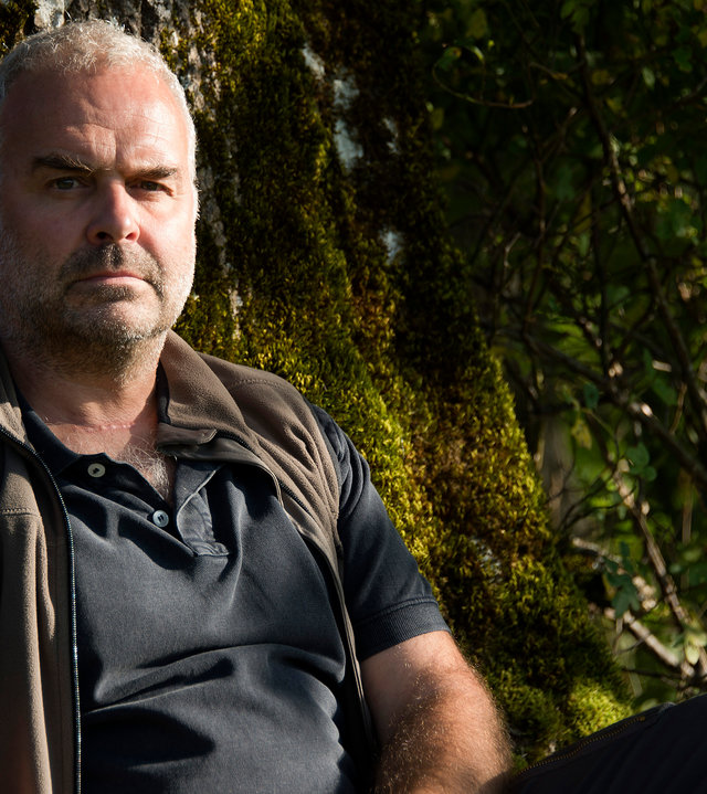 "Der Bergdoktor - Der bessere Tod (1)": Rolf Bichler (Jophi Ries) sitzt in Nahaufnahme vor einem Baum und schaut sorgenvoll in die Weite.