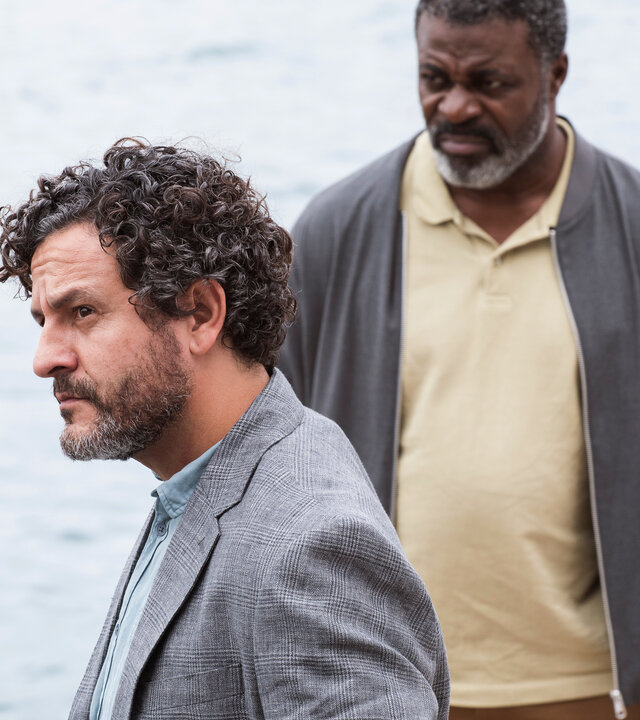 "The Diplomat - Neue Spuren": Inspector Castells (Isak Férriz) und Colin Sutherland (Danny Sapani) stehen auf einem Boot an der Reling und blicken nachdenklich in die Ferne.