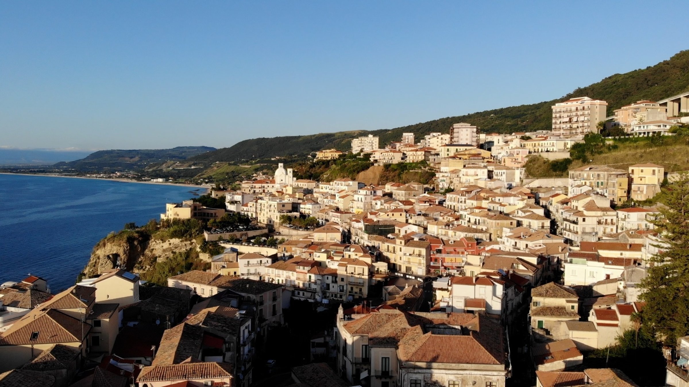"Kalabrien - Land zwischen den Meeren": Stadt an einem Berghang mit Blick auf das Meer.