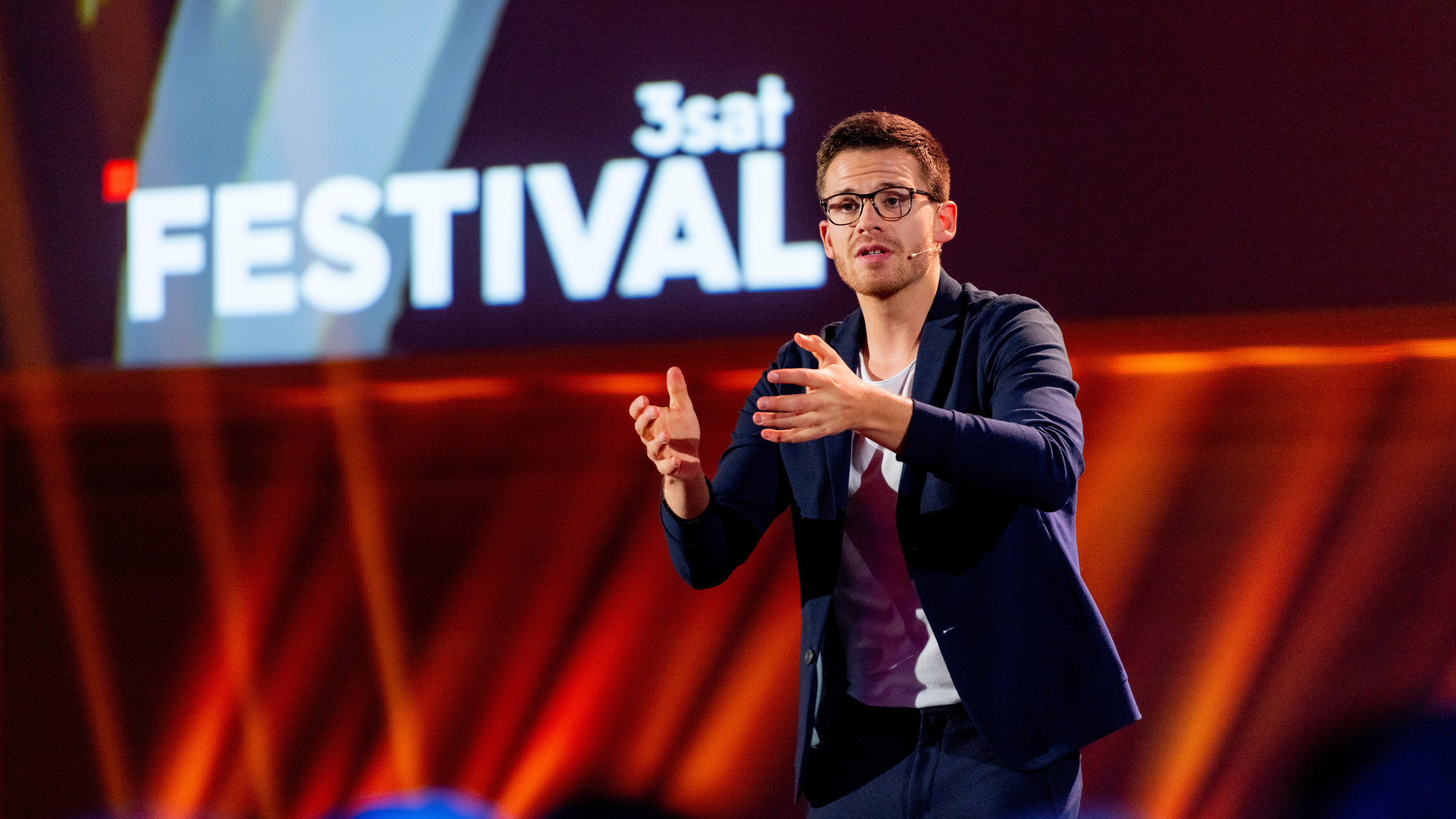 "Es kommt wie's kommt" (3satFestival 2019): Martin Frank gestikuliert auf der 3satFestival-Bühne.