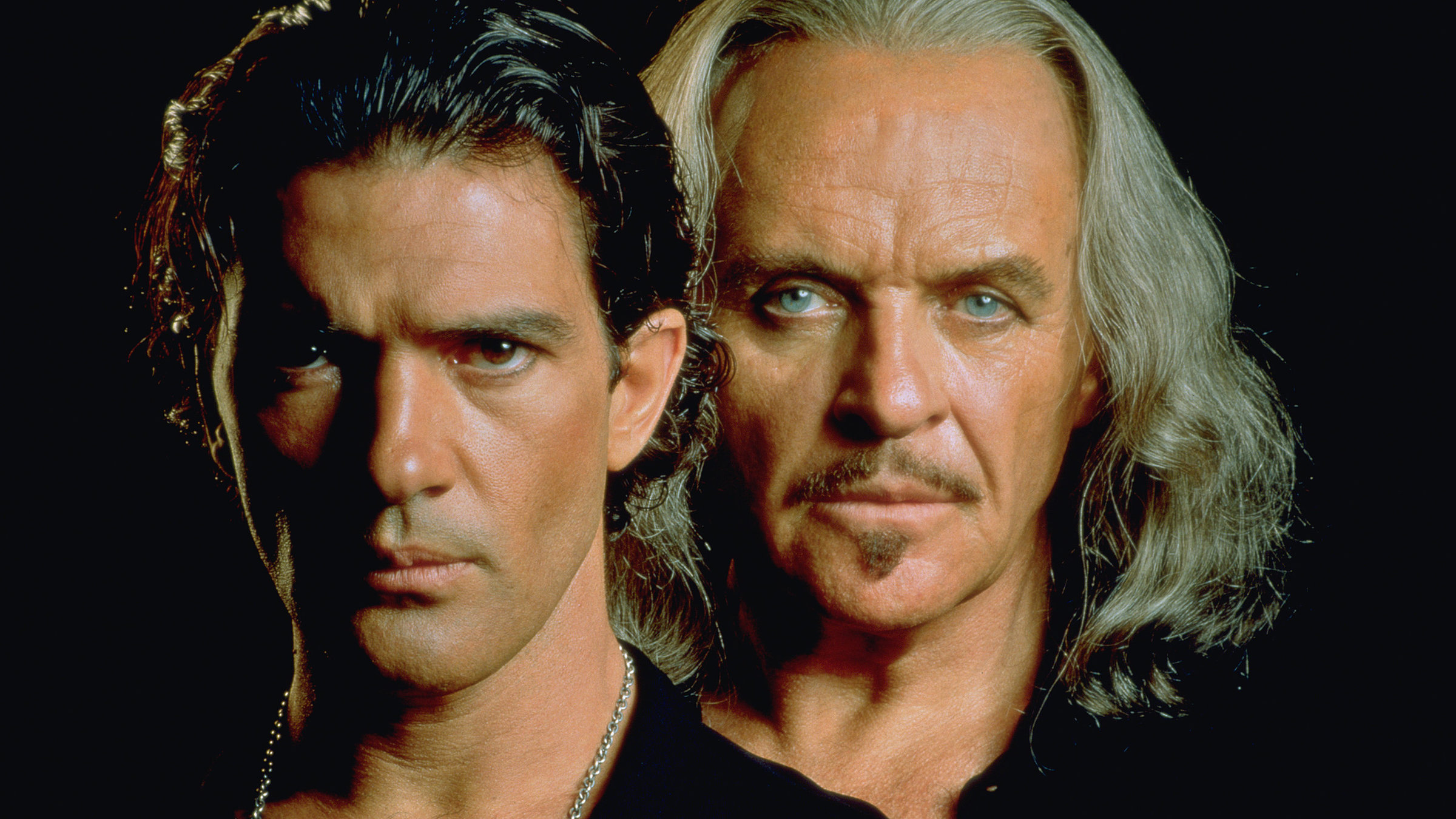 "Die Maske des Zorro": Der alte Zorro alias Don Diego De La Vega (Anthony Hopkins) und sein Nachfolger Alejandro Murrieta (Antonio Banderas) stehen dicht hintereinander und schauen mit entschlossenem Blick in die Kamera.