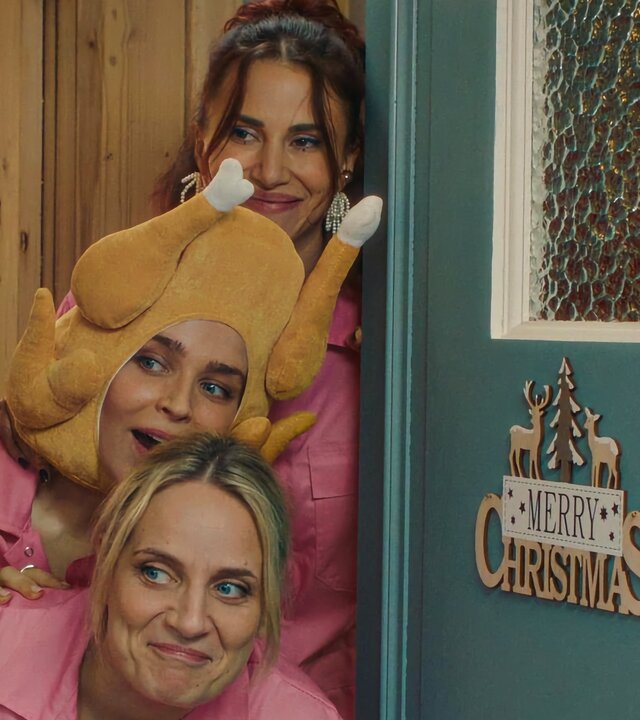 "Single Bells - Only Losers for Annie? - Piet (II)": Daffy (Lize Feryn), Mina (Julie Van den Steen), Babs (Ruth Beeckmans) haben sich hintereinander an der geöffneten Haustür postiert und schauen gespannt nach draußen.