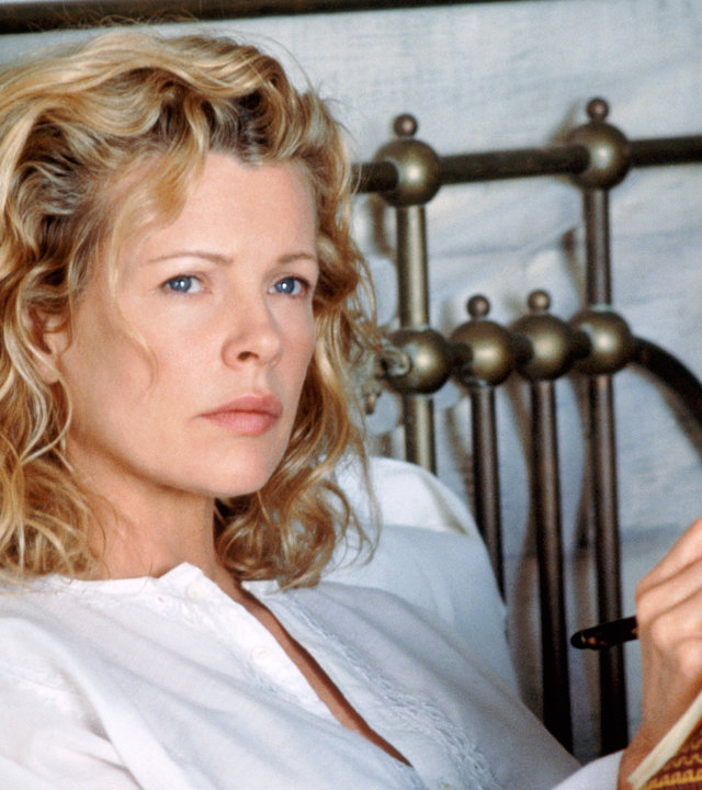"Ich träumte von Afrika": Kuki Gallmann (Kim Basinger) sitzt im Bett mit einem Notizbuch auf den Knien und blickt nachdenklich in die Ferne.