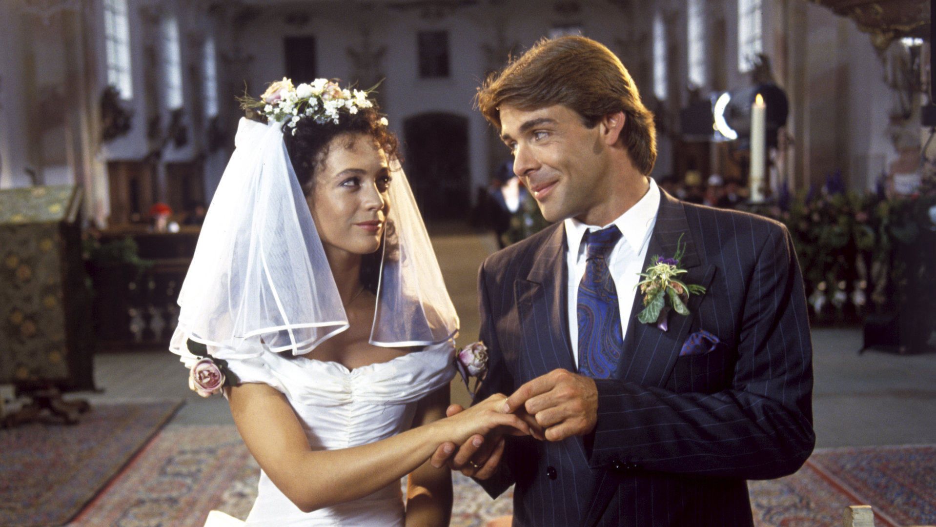 "Die Schwarzwaldklinik - Hochzeit mit Hindernissen": Udo (Sascha Hehn) steckt Elke (Barbara Wussow) den Ehering am Altar an den Finger.