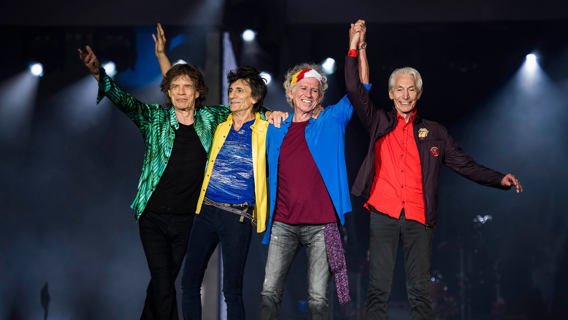 "The Rolling Stones: Licked Live in NYC": Die vier Mitglieder der Band stehen nebeneinander auf einer Bühne. Sie haben sich umarmt oder an den Händen gefasst, die sie in die Höhe strecken.