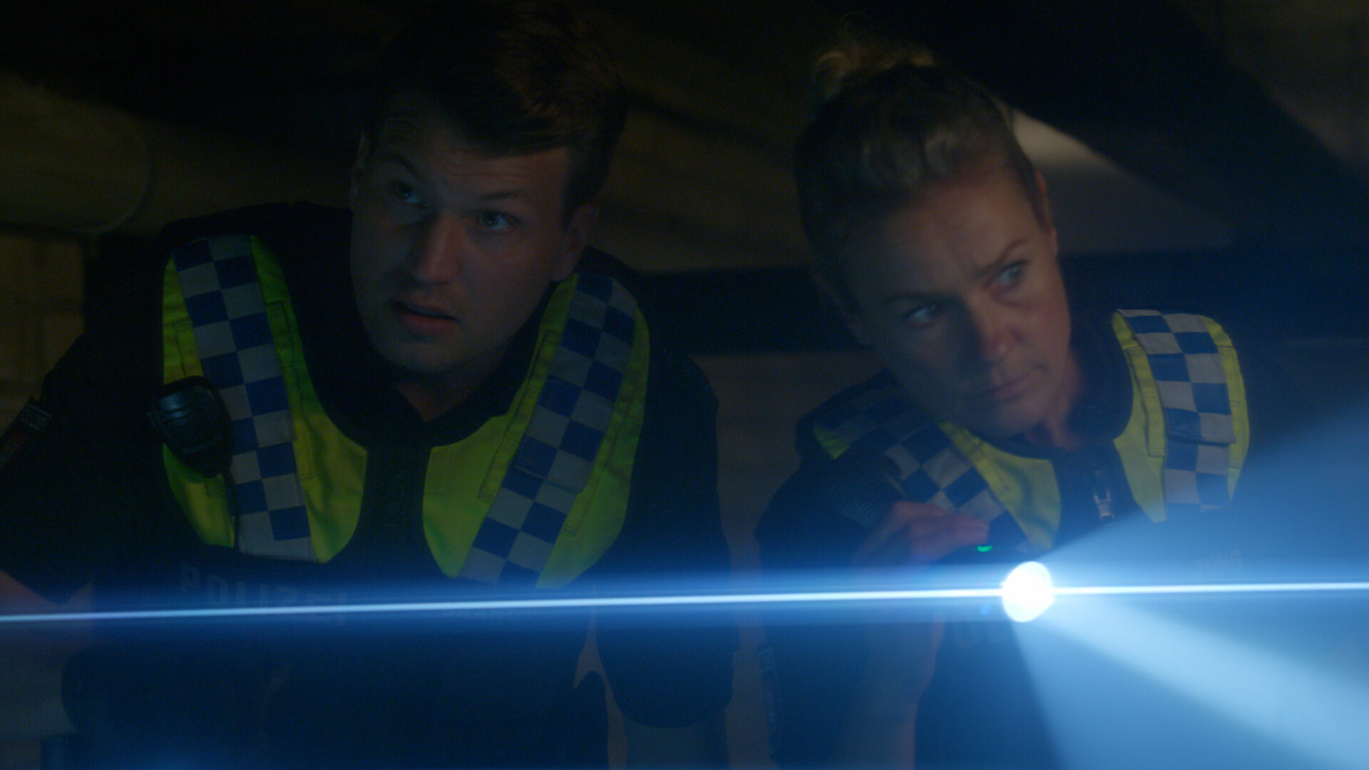 "Notruf Hafenkante - Der letzte Tag": Nahaufnahme: Polizist Nick Brandt (Raúl Richter) und seine Kollegin Franzi Jung (Rhea Harder-Vennewald) stehen dicht nebeneinander in einem dunklen Raum und leuchten mit ihren Taschenlampen.