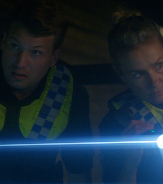 "Notruf Hafenkante - Der letzte Tag": Nahaufnahme: Polizist Nick Brandt (Raúl Richter) und seine Kollegin Franzi Jung (Rhea Harder-Vennewald) stehen dicht nebeneinander in einem dunklen Raum und leuchten mit ihren Taschenlampen.