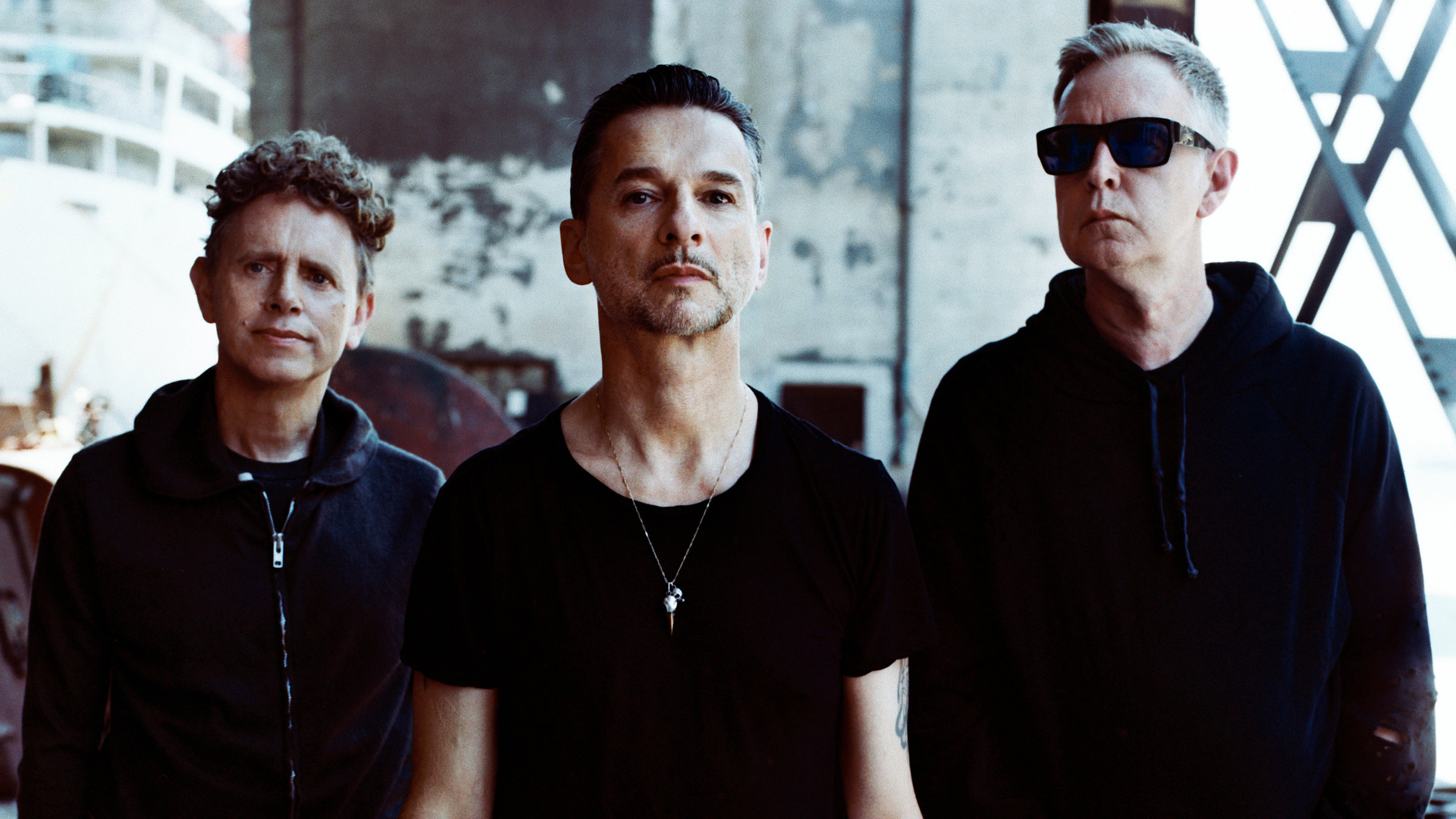 "Depeche Mode: One Night in Paris": Die drei Männer der Gruppe Depeche Mode stehen nebeneinander in schwarzen Thirts und gucken direkt in die Kamera.