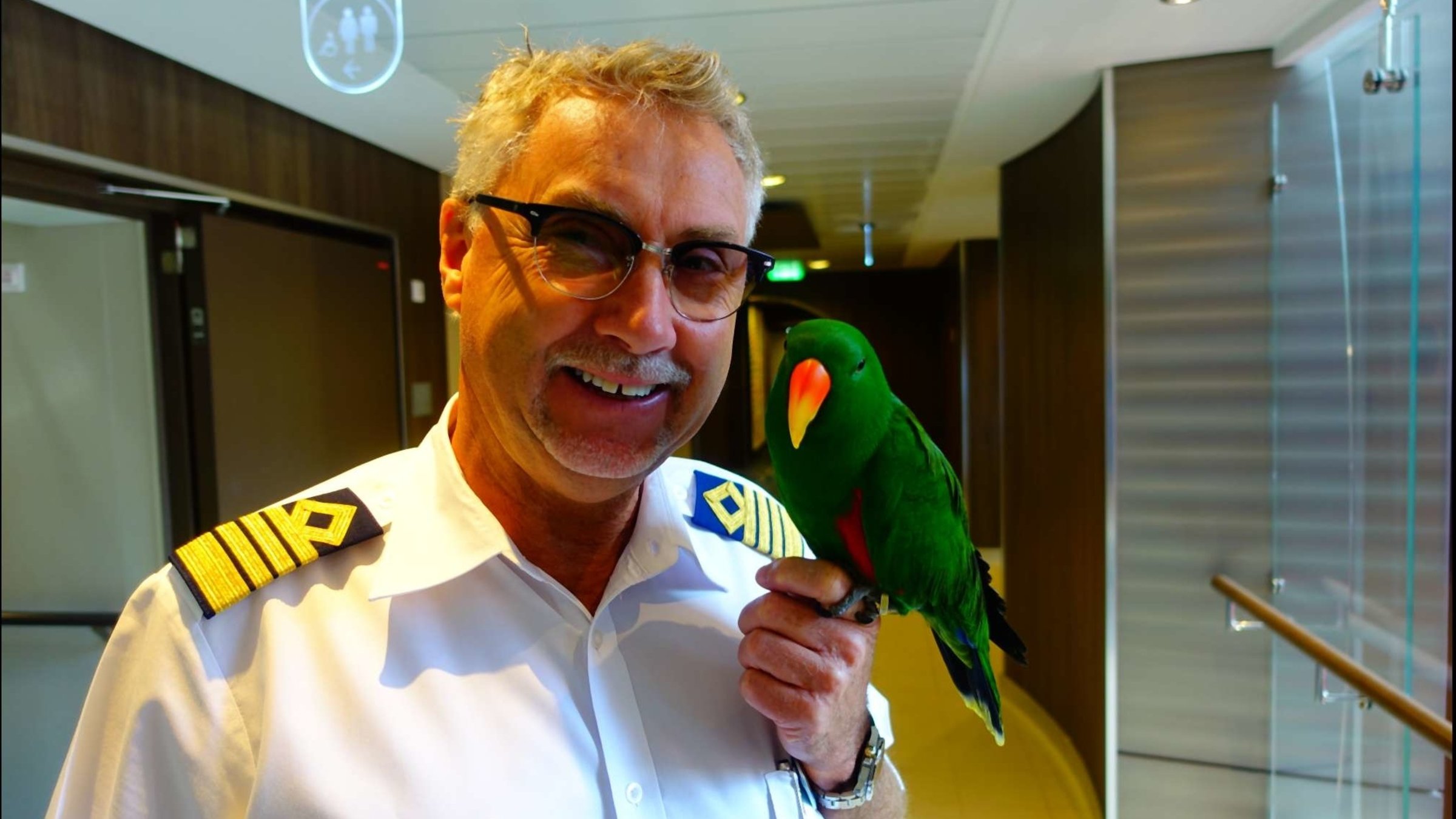 "ZDF.reportage: Kreuzfahrt XXL - Freizeitstress in der Karibik": Kapitän Jonny und sein Papagei in Nahaufnahme.