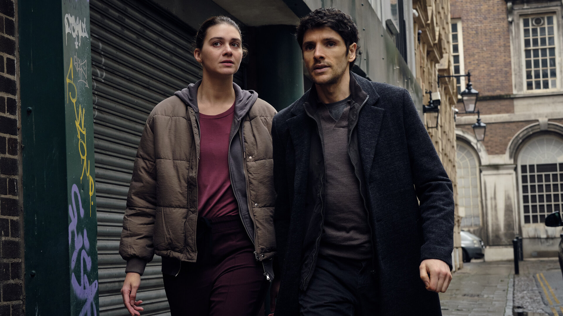 "The Killing Kind: Alles auf Anfang": John Webster (Colin Morgan) und Ingrid Lewis (Emma Appleton) gehen eng nebeneinander mit entschlossenem Blick eine Straße entlang.