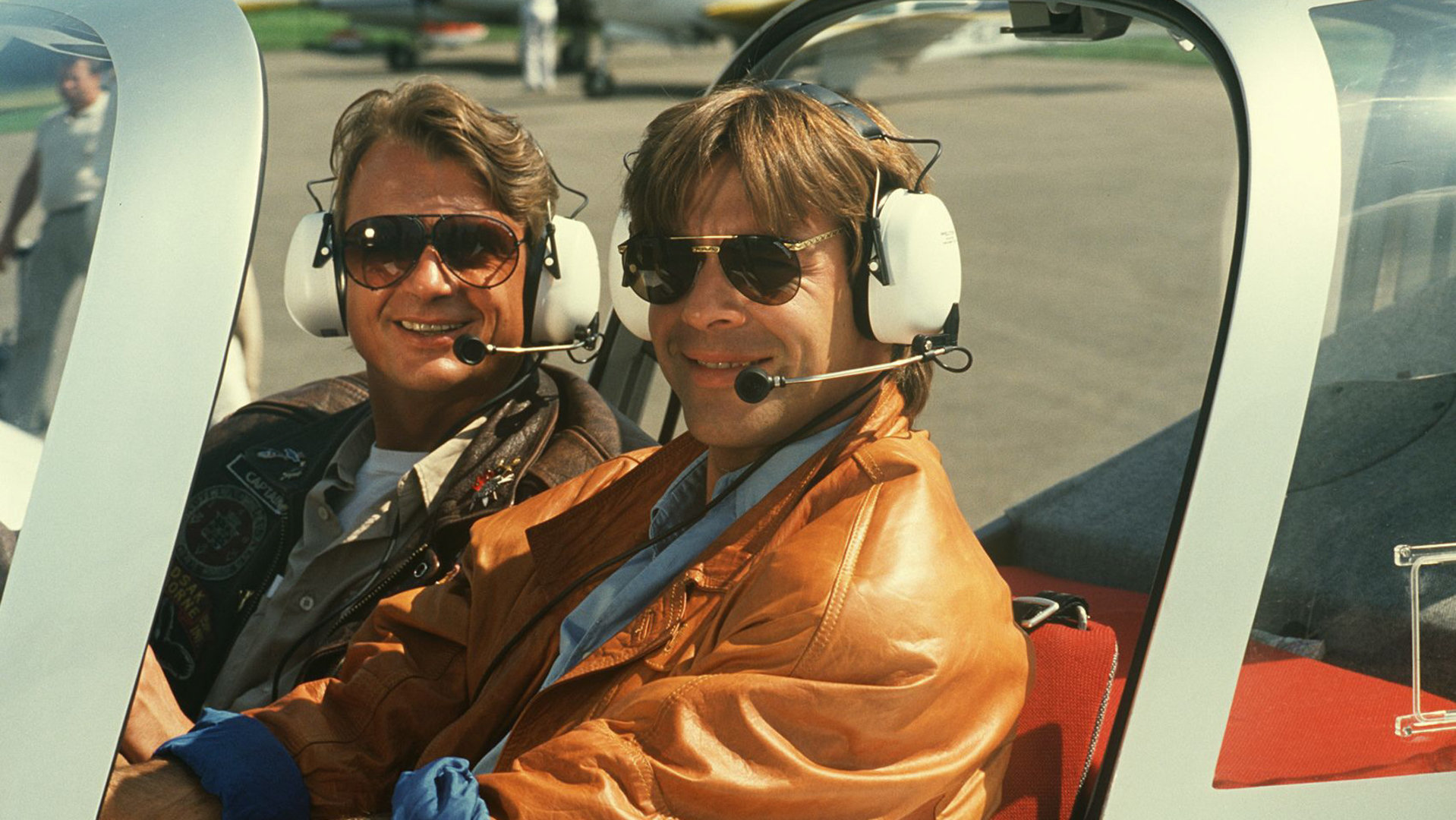 "Schwarzwaldklinik - Arzt unter Verdacht": Udo (Sascha Hehn) sitzt neben seinem Fluglehrer Achim Sander (Krystian Martinek) im Cockpit einer Cessna und strahlt in die Kamera.
